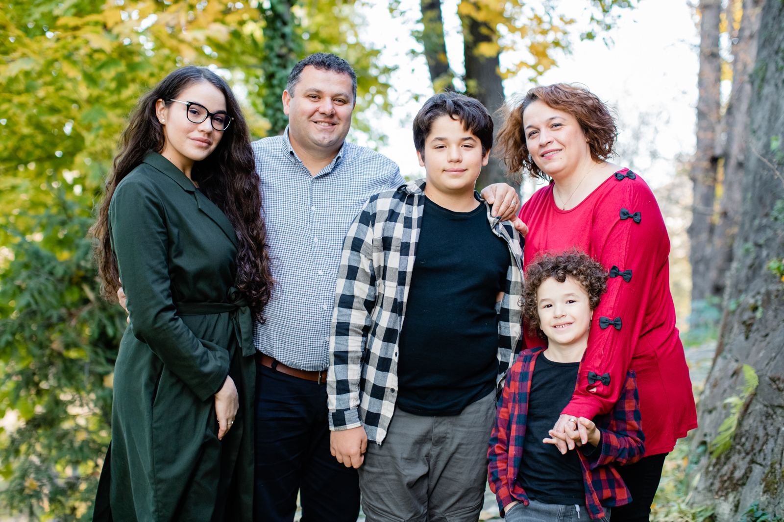 Liviu en Elena Tudosie met hun drie kinderen tussen de herfstbomen